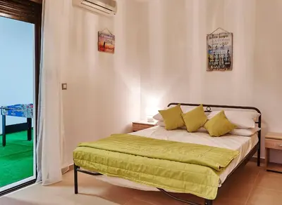 a bedroom with a bed with a green blanket at Villa Tamara in vlicha