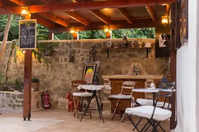 a patio with tables and stools in a restaurant at Kristina´s rooms in Rhodes Town