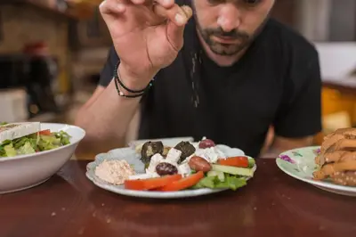 a man sitting at a table with plates of food at Kristina´s rooms in Rhodes Town