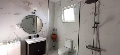a bathroom with a sink and a mirror and a toilet at Villa Irene Lindos, Lindos 10 mins, Beach 4 mins, Amazing Views 0 mins in Kalathos