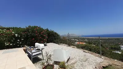 a patio with two chairs and a view of the ocean at Villa Irene Lindos, Lindos 10 mins, Beach 4 mins, Amazing Views 0 mins in Kalathos