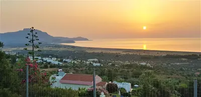 a view of a beach at sunset with the sun setting at Villa Irene Lindos, Lindos 10 mins, Beach 4 mins, Amazing Views 0 mins in Kalathos