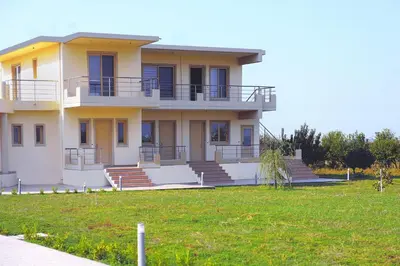 a large building with stairs and a grass field at Stelia Luxury apartments in Kalavárda