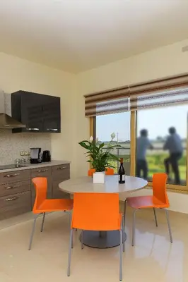 a kitchen with a table and chairs and a table and a window at Stelia Luxury apartments in Kalavárda