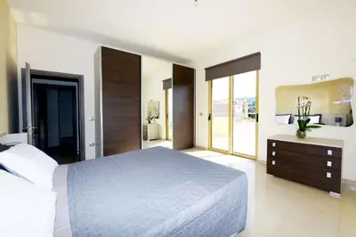 a bedroom with a large bed and a large mirror at Stelia Luxury apartments in Kalavárda