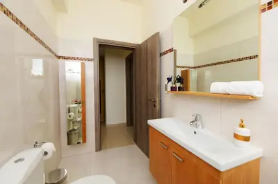 a bathroom with a sink and a toilet and a mirror at Stelia Luxury apartments in Kalavárda