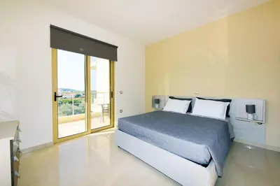 a bedroom with a bed and a large window at Stelia Luxury apartments in Kalavárda