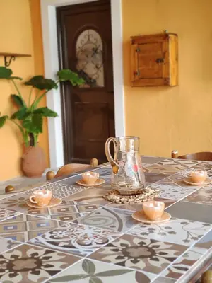 a table with a glass vase on top of it at Archangelos Family House in Archangelos