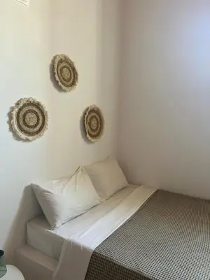 a bed in a room with two baskets on the wall at Archangelos Family House in Archangelos