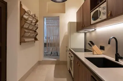 a kitchen with wooden cabinets and a sink and a window at Lindian Plumeria in Líndos