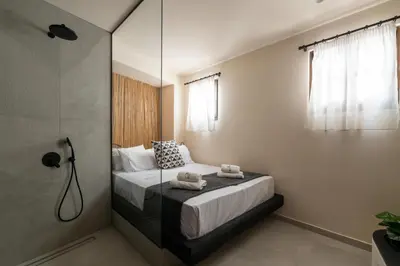 a bedroom with a bed and a shower at Lindian Plumeria in Líndos