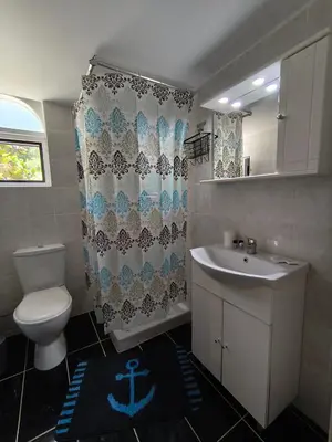 a bathroom with a sink and a toilet and a shower curtain at Cozy apartment in Triánta