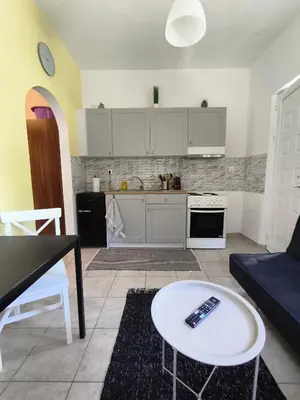 a living room with a table and a kitchen at Cozy apartment in Triánta