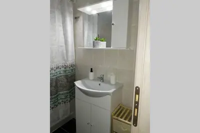 a white bathroom with a sink and a mirror at Cozy apartment in Triánta