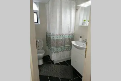 a bathroom with a toilet and a sink at Cozy apartment in Triánta