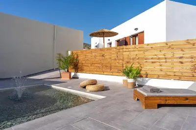 a backyard with a wooden fence and a bench at Casa di Giorgio in Kattavía
