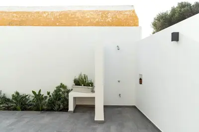 a room with white walls and a bench with a potted plant at Casa di Giorgio in Kattavía