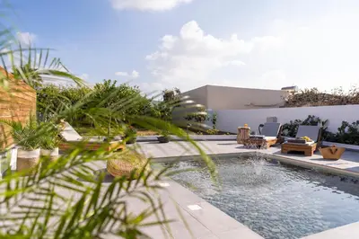 a swimming pool in the middle of a yard with chairs at Casa di Giorgio in Kattavía