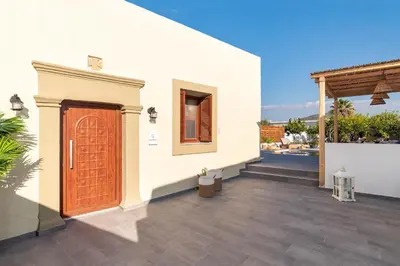 a house with a wooden door on a patio at Casa di Giorgio in Kattavía
