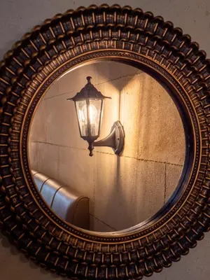 a mirror with a lamp and a light on a wall at Casa Theano - Old Town in Rhodes Town