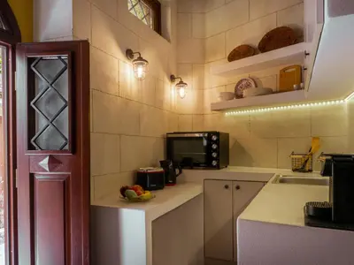 a small kitchen with a microwave and a sink at Casa Theano - Old Town in Rhodes Town