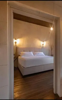 a bedroom with a large white bed with two lights at Casa Theano - Old Town in Rhodes Town