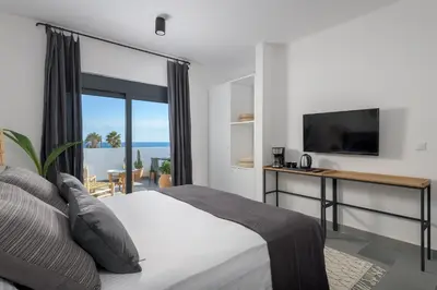 a bedroom with a bed with a desk and a television at Seawater Villa - Luxury Pool Retreat - 150m Beach in Lachania