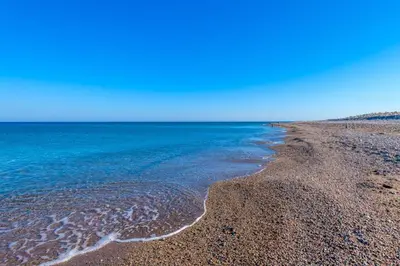 a beach with blue water and a rocky shore at Seawater Villa - Luxury Pool Retreat - 150m Beach in Lachania