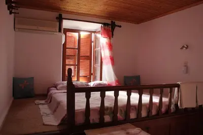 a bedroom with a bed and a window with a dress at Electra in Líndos