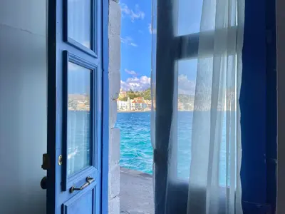 an open door with a view of the ocean at Seafront - Harbour view , Pitini 2 in Symi