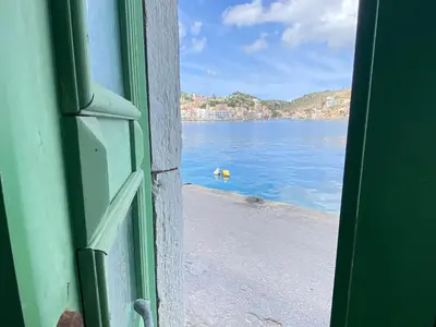 an open door with a view of a body of water at Seafront - Harbour view , Pitini 1 in Symi
