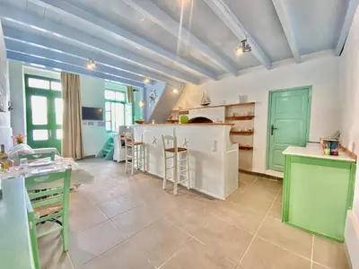 a large kitchen with green cabinets and a counter at Seafront - Harbour view , Pitini 1 in Symi
