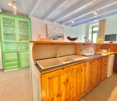 a kitchen with green cabinets and a sink at Seafront - Harbour view , Pitini 1 in Symi