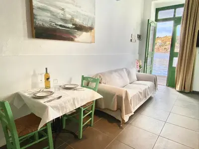 a living room with a table and a couch at Seafront - Harbour view , Pitini 1 in Symi