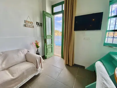a living room with a couch and a view of the ocean at Seafront - Harbour view , Pitini 1 in Symi