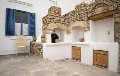 a room with a stone wall and a table and chair at Anastasia Traditional House in Lardos