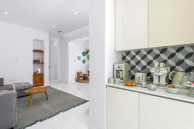 a kitchen with white cabinets and a living room at Seashore Villa - Luxury Beachfront - Pool & Sea View in Lachania