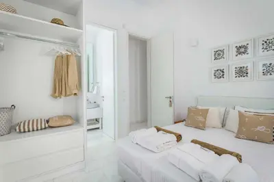 a white room with a bed and a mirror at Seashore Villa - Luxury Beachfront - Pool & Sea View in Lachania