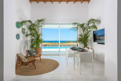 a dining room with a table and chairs and plants at Seashore Villa - Luxury Beachfront - Pool & Sea View in Lachania