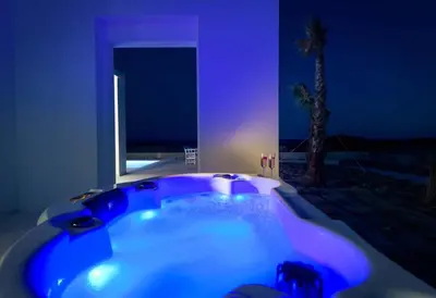 a blue bath tub in a room with a palm tree at Seashore Villa - Luxury Beachfront - Pool & Sea View in Lachania