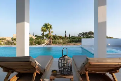 a view of a swimming pool from a house with two chairs at Seasand Villa - Luxury Pool Retreat - 150m Beach in Lachania