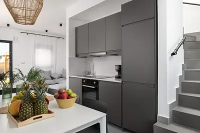 a kitchen with a table with a bowl of fruit at Seasand Villa - Luxury Pool Retreat - 150m Beach in Lachania