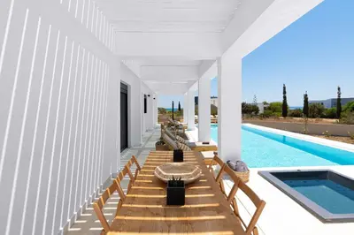 a pool house with wooden benches and a swimming pool at Seasand Villa - Luxury Pool Retreat - 150m Beach in Lachania
