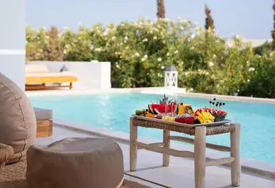 a tray of fruit on a table next to a pool at Seasand Villa - Luxury Pool Retreat - 150m Beach in Lachania