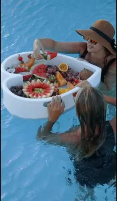 two people in the water with a tray of fruit at Seasand Villa - Luxury Pool Retreat - 150m Beach in Lachania