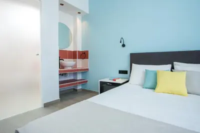 a bedroom with a white bed with a yellow pillow at Faliraki Premium Hotel in Faliraki