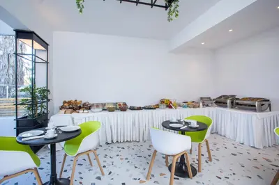a dining room with two tables and green chairs at Faliraki Premium Hotel in Faliraki