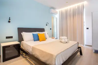 a bedroom with a large bed with colorful pillows at Faliraki Premium Hotel in Faliraki