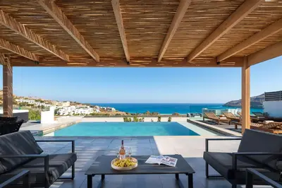 a patio with a table and a swimming pool at Villa Rocabella with heated pool & jacuzzi in Lindos in vlicha