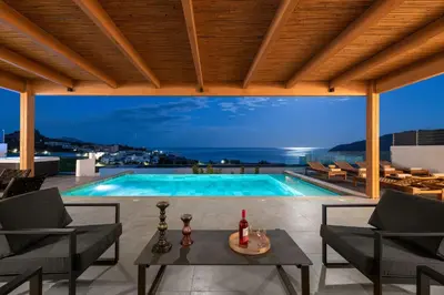 a villa with a swimming pool at night at Villa Rocabella with heated pool & jacuzzi in Lindos in vlicha